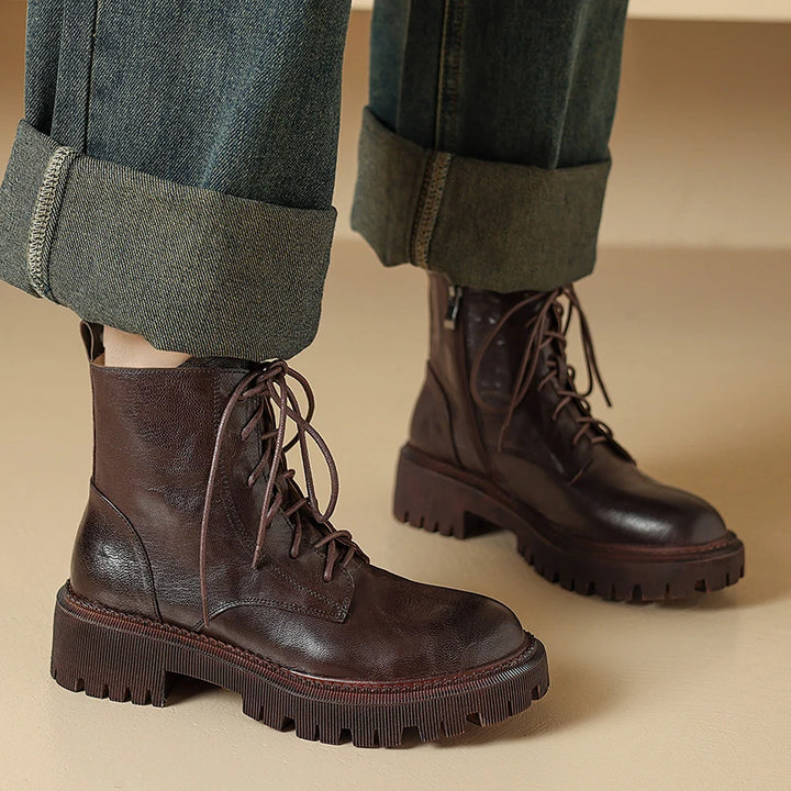 Model wearing brown lace-up ankle boots with cuffed jeans