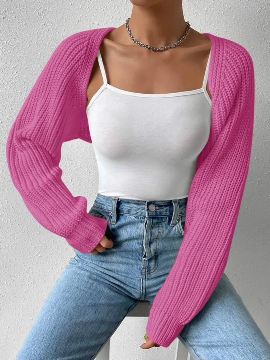 Woman wearing pink ribbed knit cropped shrug over white cami and jeans