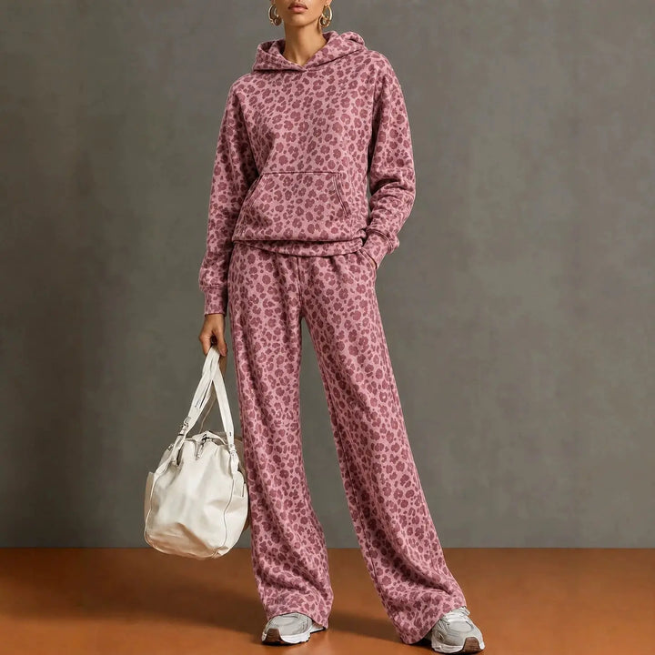 Woman wearing pink leopard print hooded sweatshirt and wide leg pants set