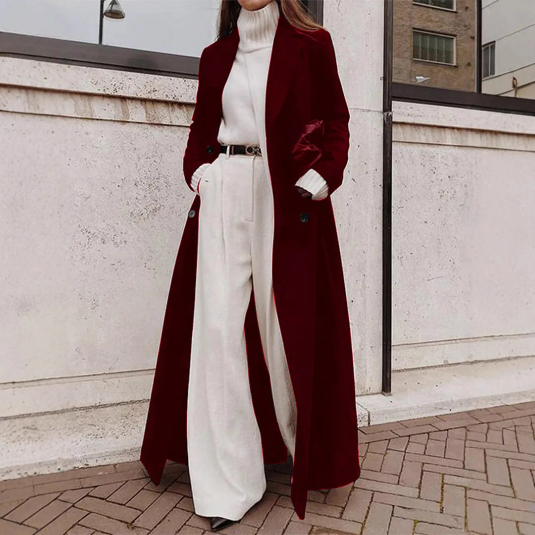 Woman wearing deep red long trench coat over white turtleneck