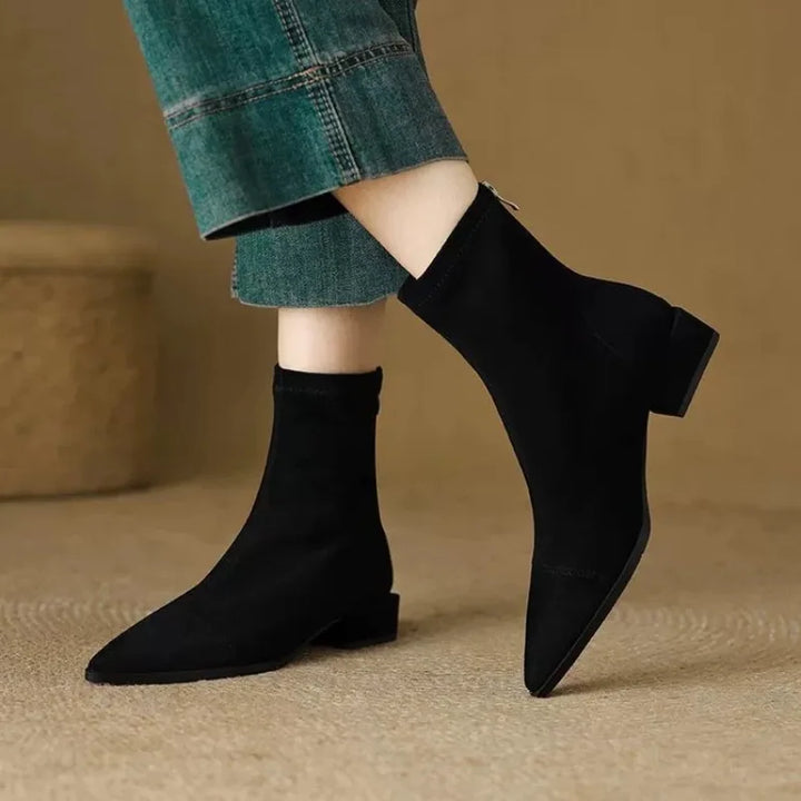 Model walking in black suede ankle boots