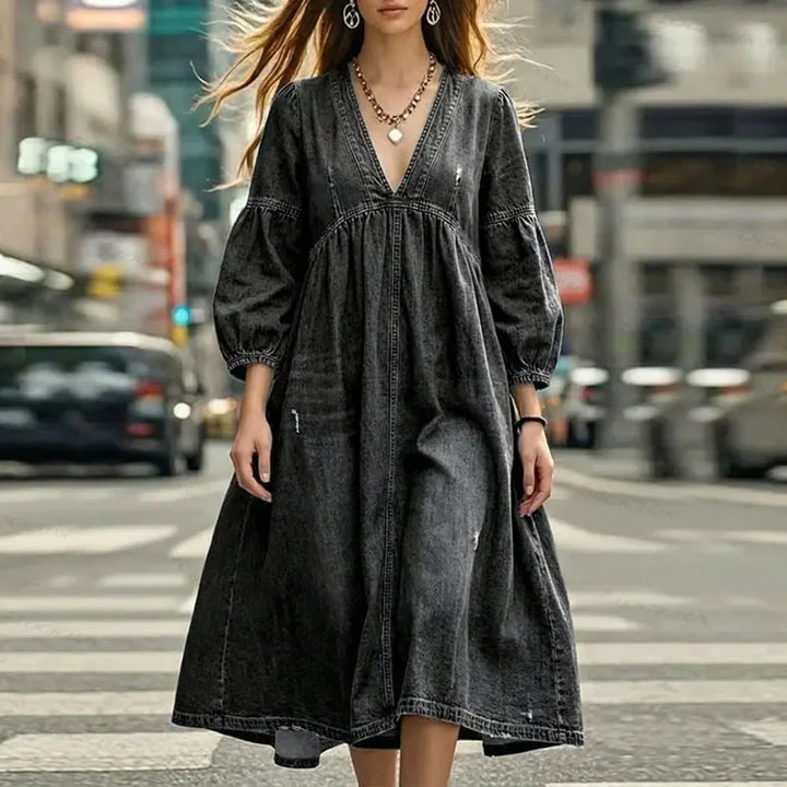 Woman in black denim A-line dress with puff sleeves, close view