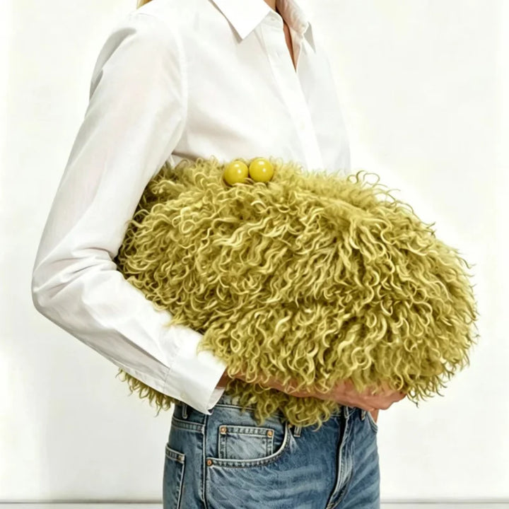 Woman carrying a yellow curly faux fur clutch bag under her arm