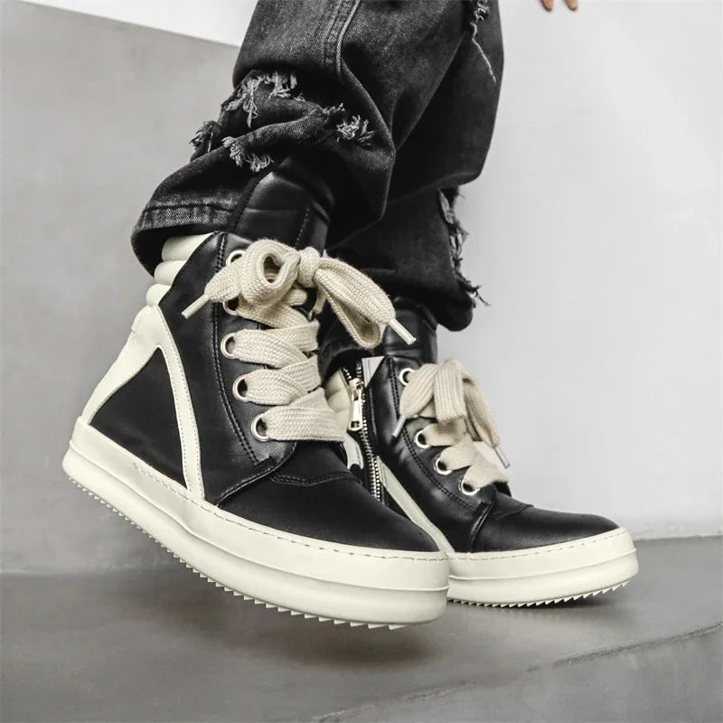 Black high-top sneakers worn with jeans, side zip detail