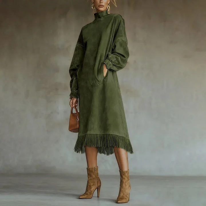 Woman wearing green mock neck sweatshirt dress with tassel fringe hem, front view