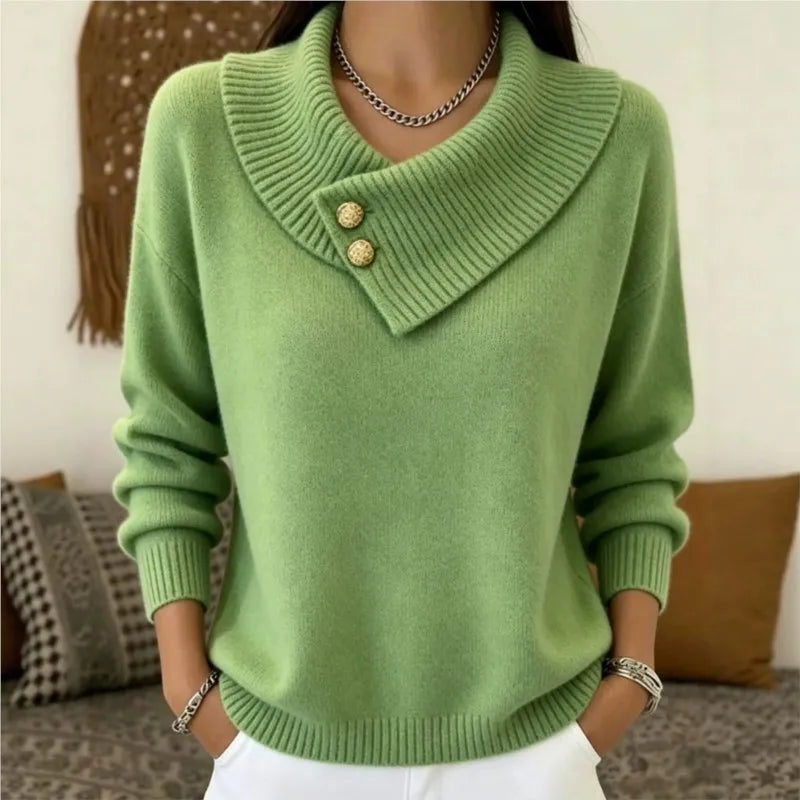 Woman wearing green sweater with asymmetric ribbed collar and gold buttons