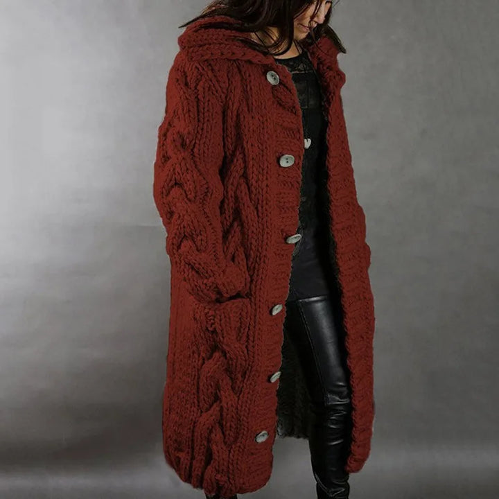Woman wearing burgundy hooded cable knit long cardigan, side view