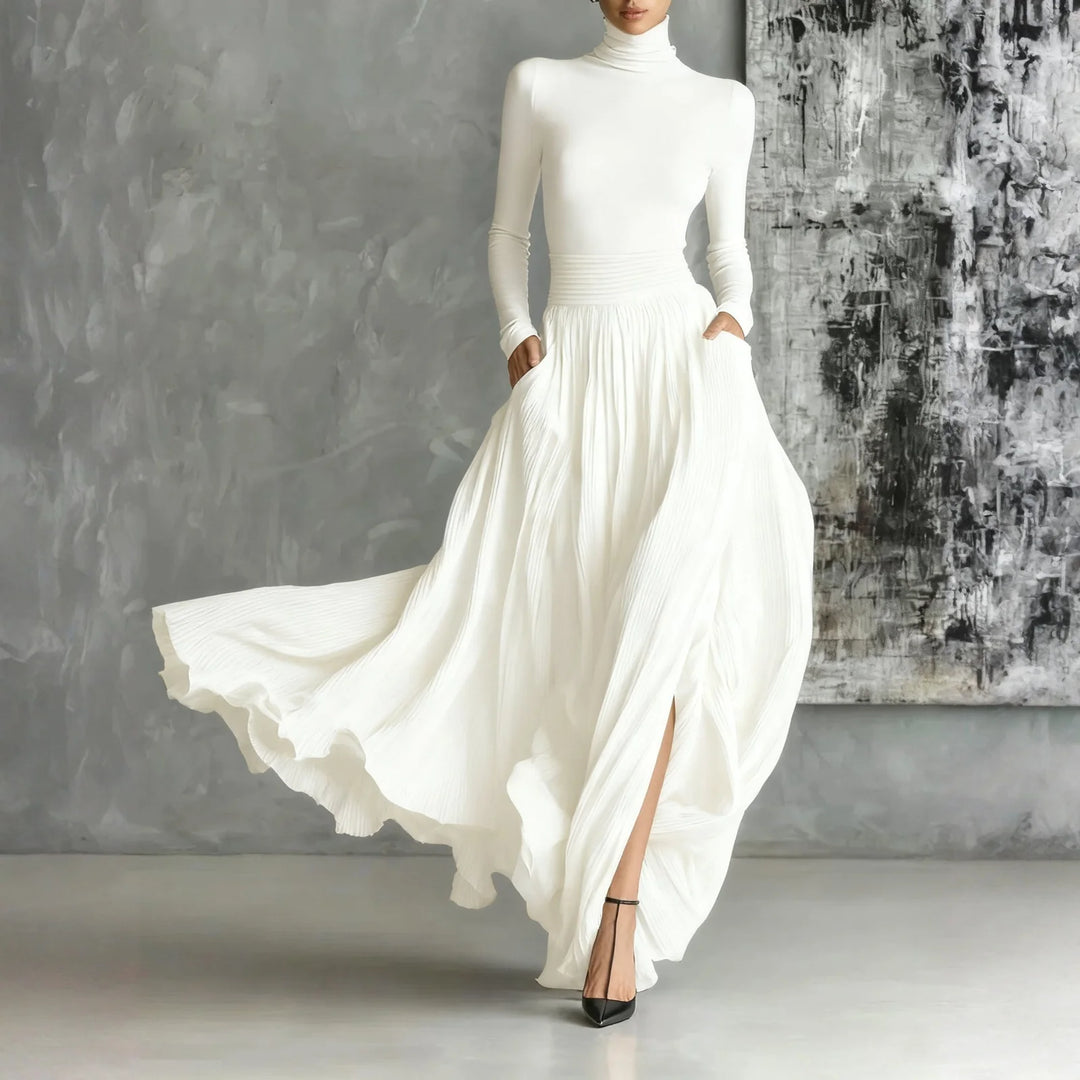 Woman in white turtleneck pleated maxi dress with side slit, front view