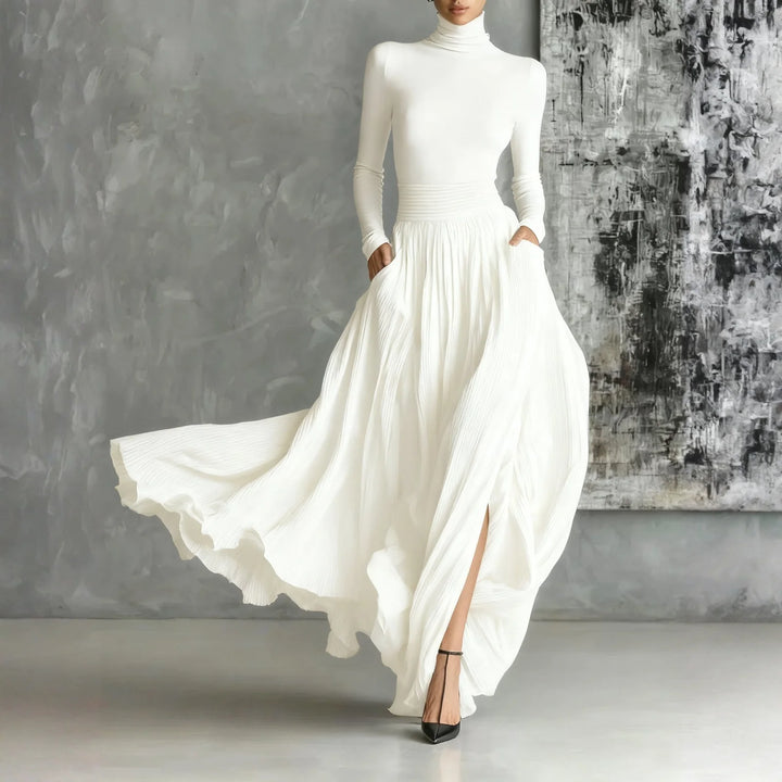 Woman in white turtleneck pleated maxi dress with side slit, front view