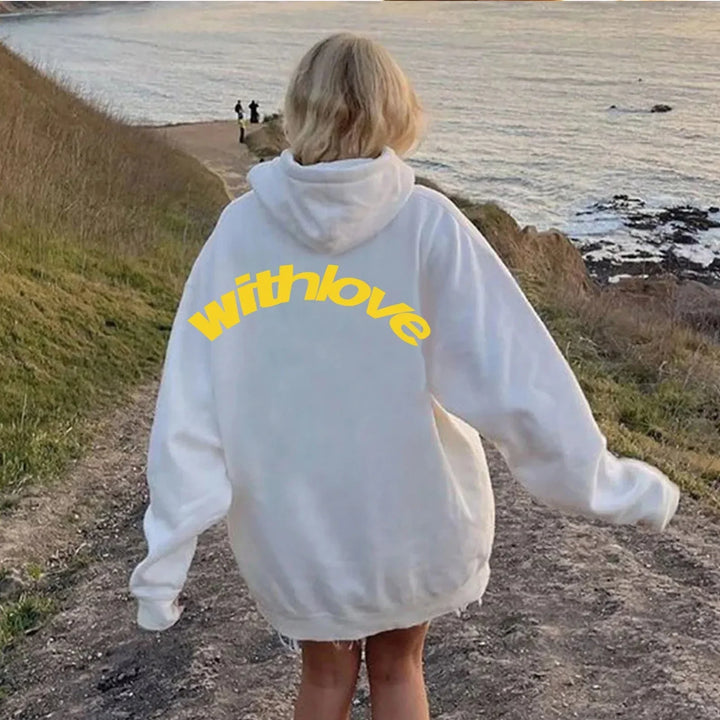 Woman wearing white withlove hoodie outdoors