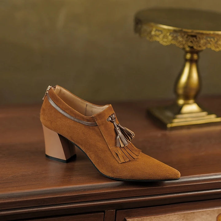 Side view of brown suede pump on wooden surface