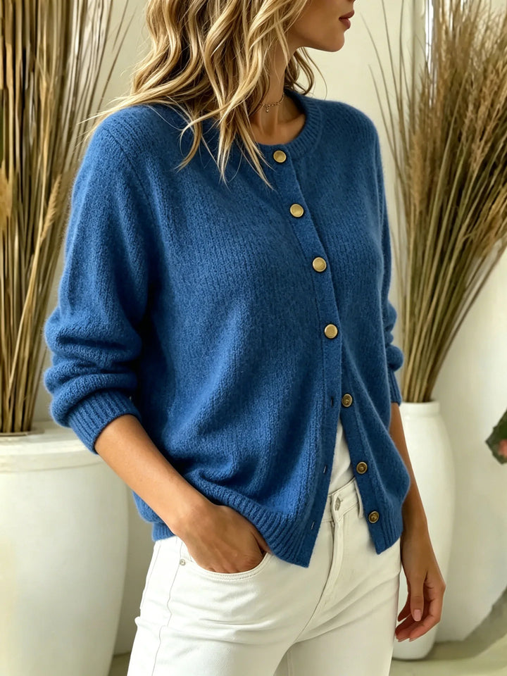 Three-quarter view of blue ribbed knit cardigan with gold buttons