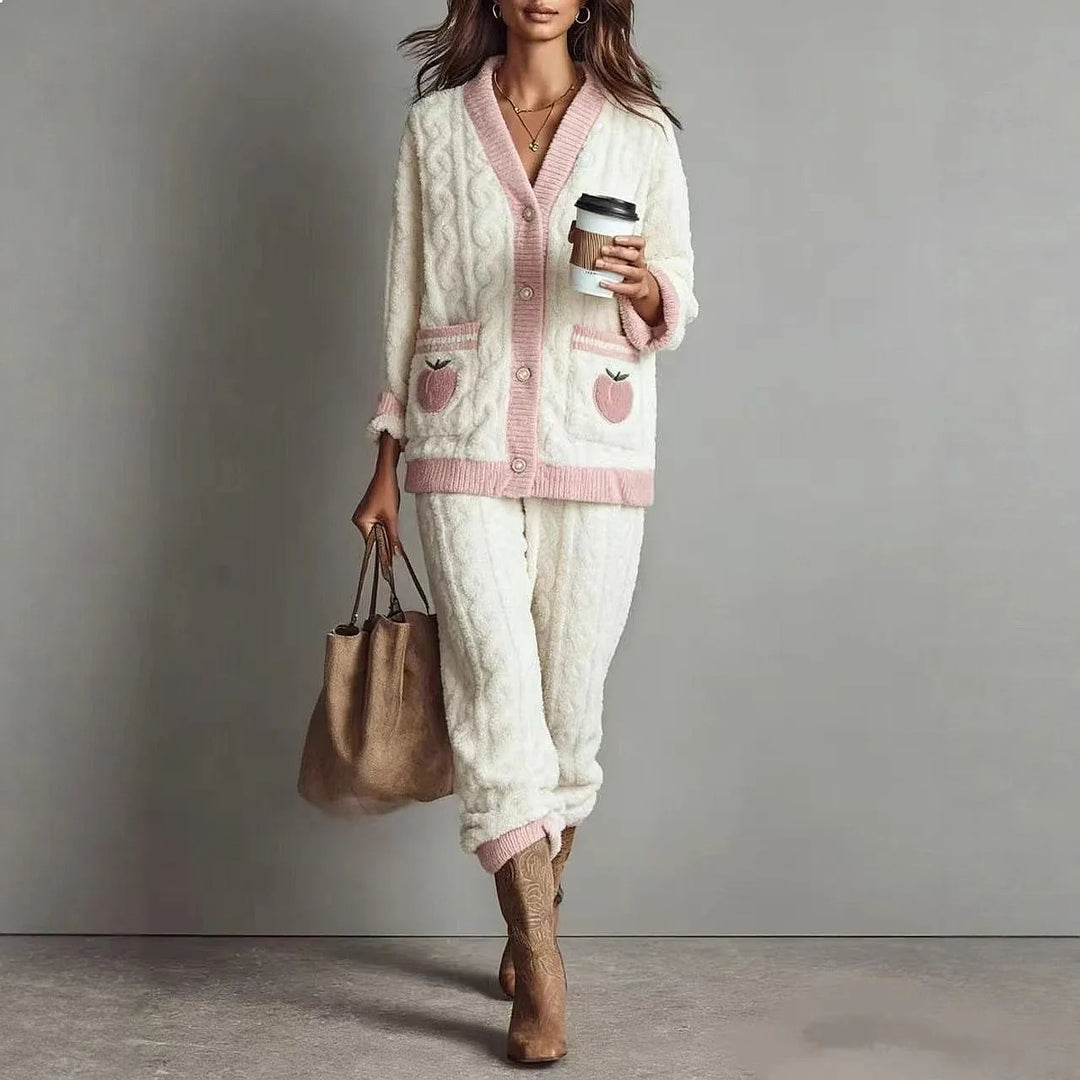 Woman wearing white cable knit cardigan and pants loungewear set with pink trim