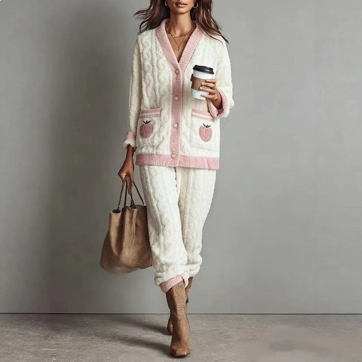 Woman wearing white cable knit cardigan and pants loungewear set with pink trim