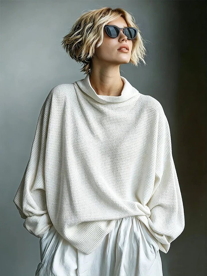 Woman in sunglasses wearing white waffle knit top with funnel collar