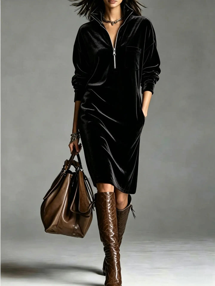 Woman in black velvet half-zip midi dress with patch pocket