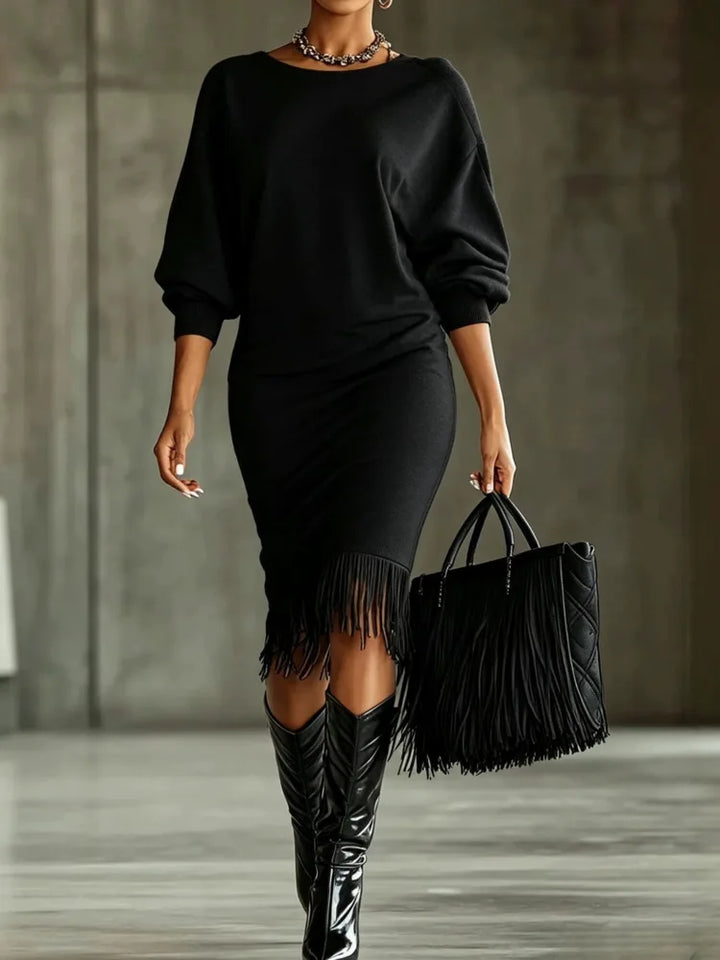 Woman wearing black fringe hem sweater dress with fringe tote bag