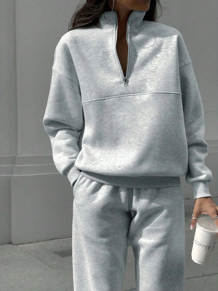 Woman wearing light gray half-zip pullover and jogger set