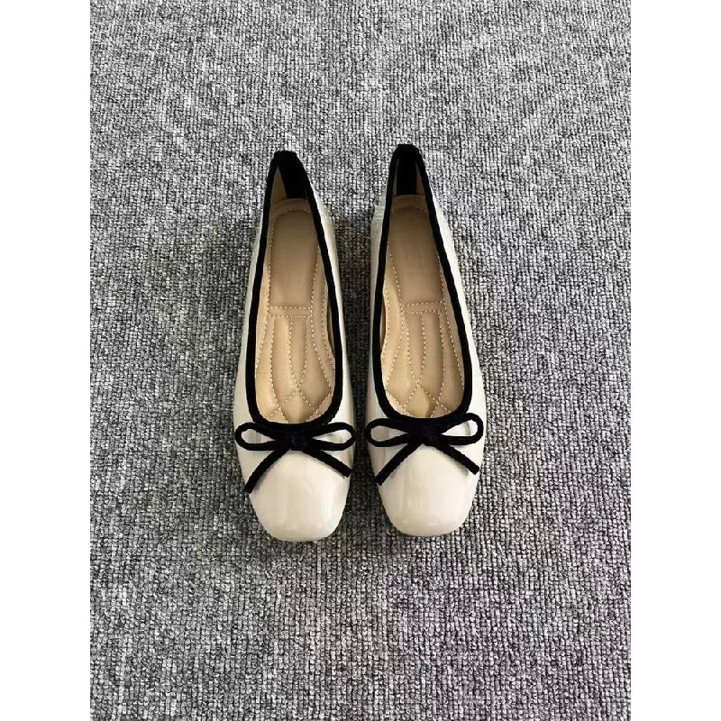 Off-white ballet flats with black trim, top view