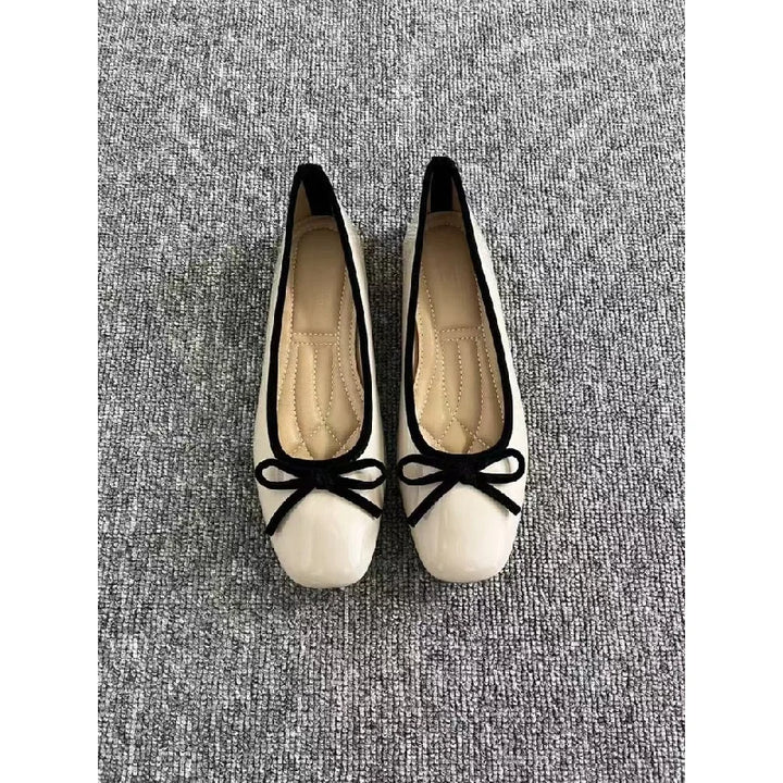 Off-white ballet flats with black trim, top view