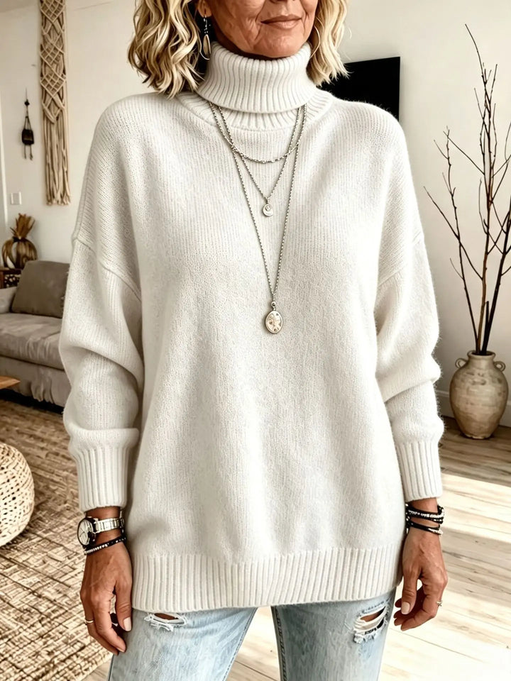 Close-up of woman in white turtleneck sweater with layered necklaces