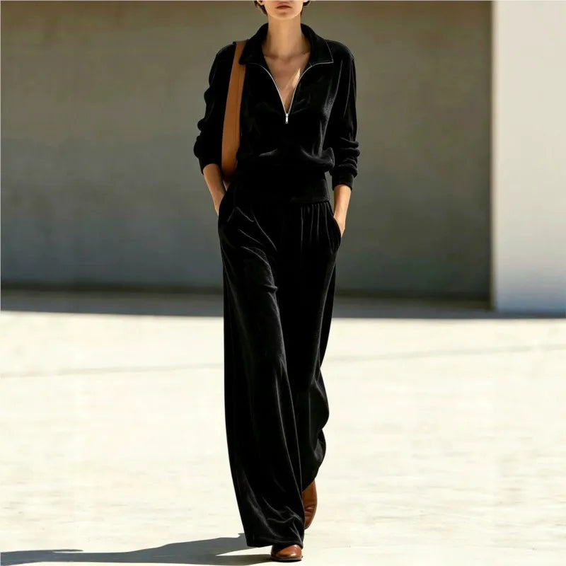Woman wearing black velour half-zip top and wide leg pants set, front view walking
