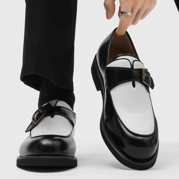 Man wearing black and white two-tone buckle loafers with black trousers
