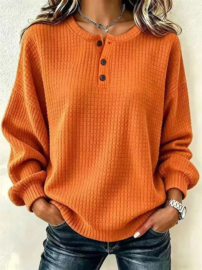 Woman wearing orange waffle knit henley pullover with button placket