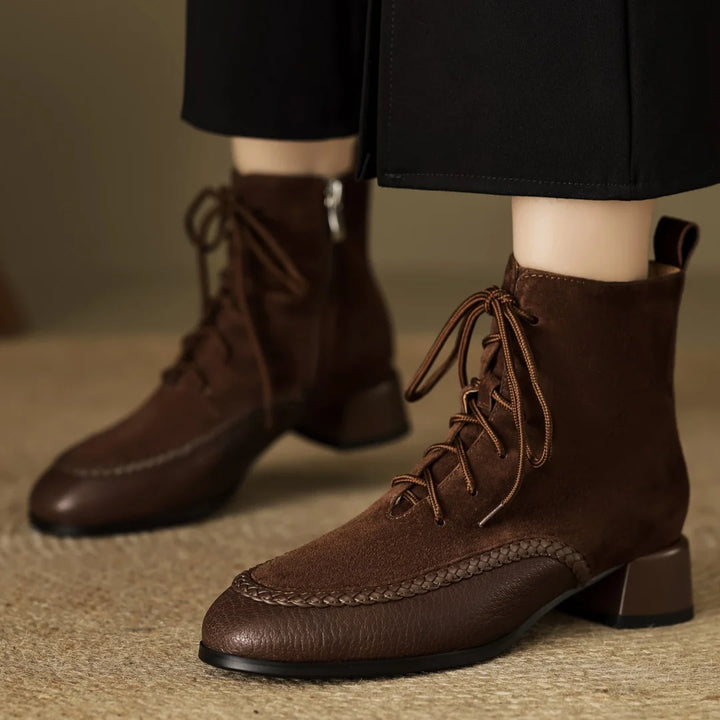 Model wearing brown suede lace-up ankle boots with black trousers