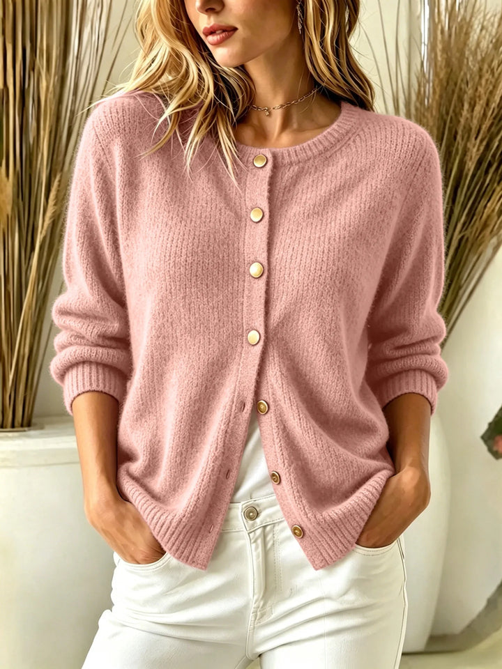 Close up of pink ribbed knit cardigan with gold buttons