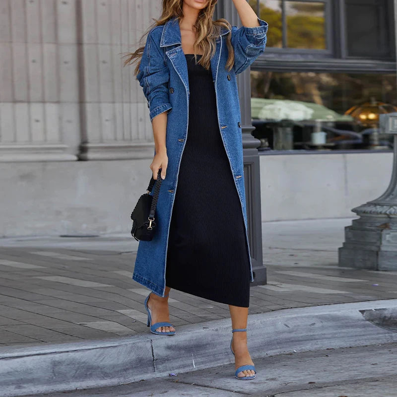Woman wearing blue denim trench coat open over black dress