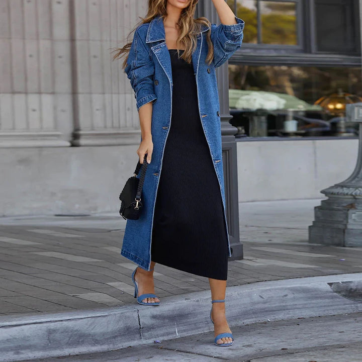 Woman wearing blue denim trench coat open over black dress