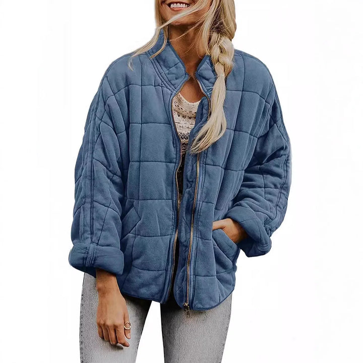 Woman wearing blue quilted bomber jacket, front view