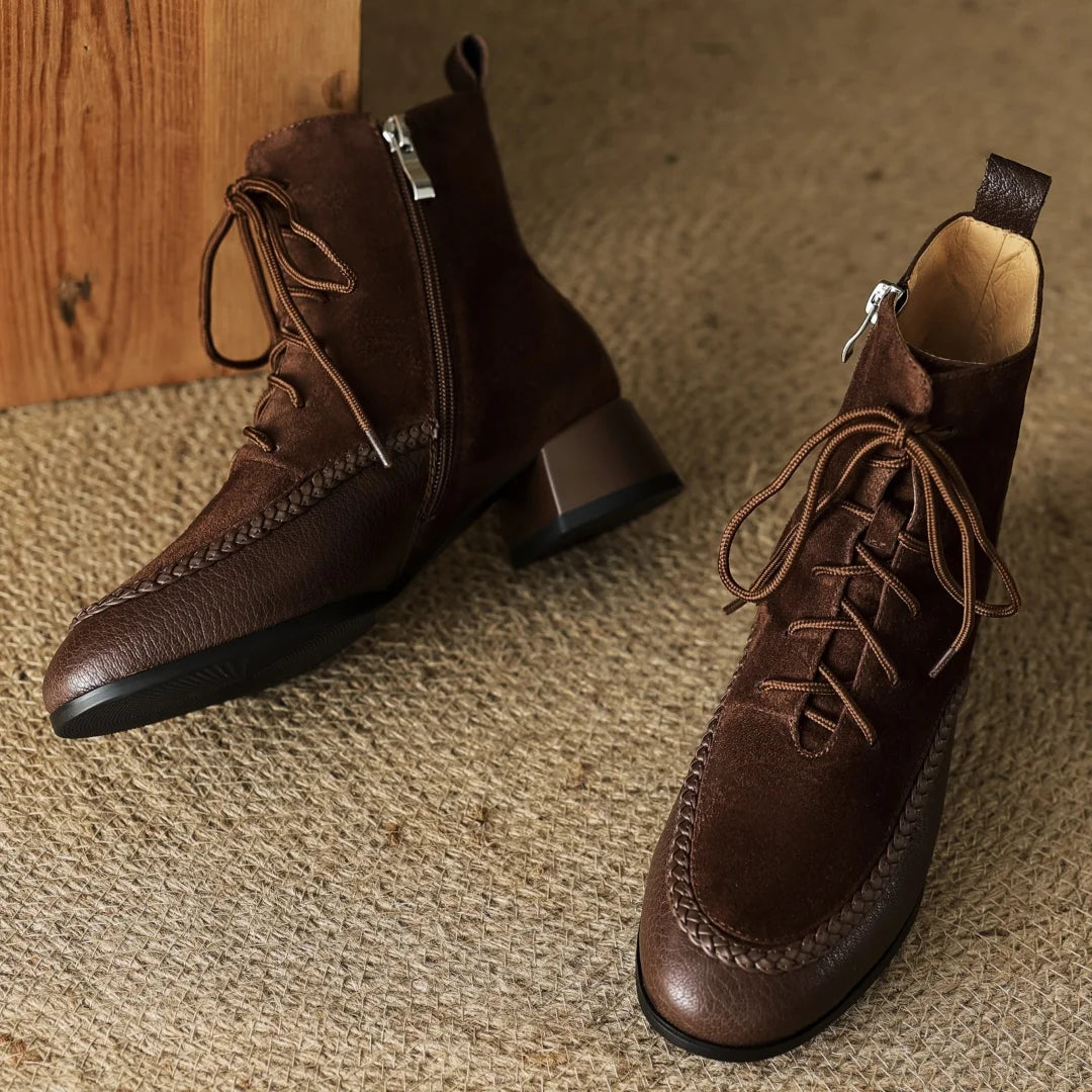 Pair of brown suede lace-up ankle boots on rug