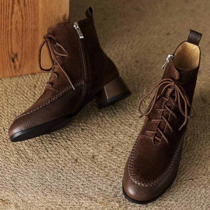Pair of brown suede lace-up ankle boots on rug
