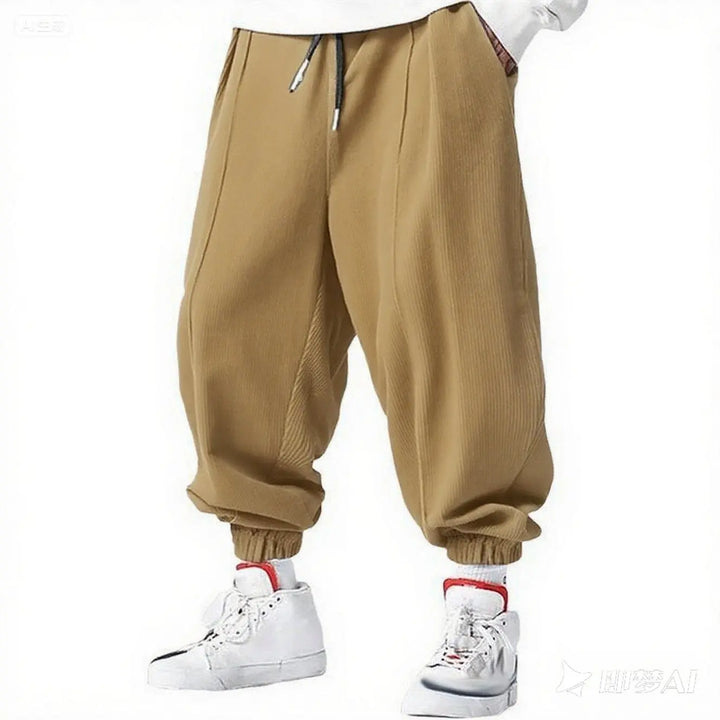 Man wearing khaki corduroy jogger pants with elastic cuffs