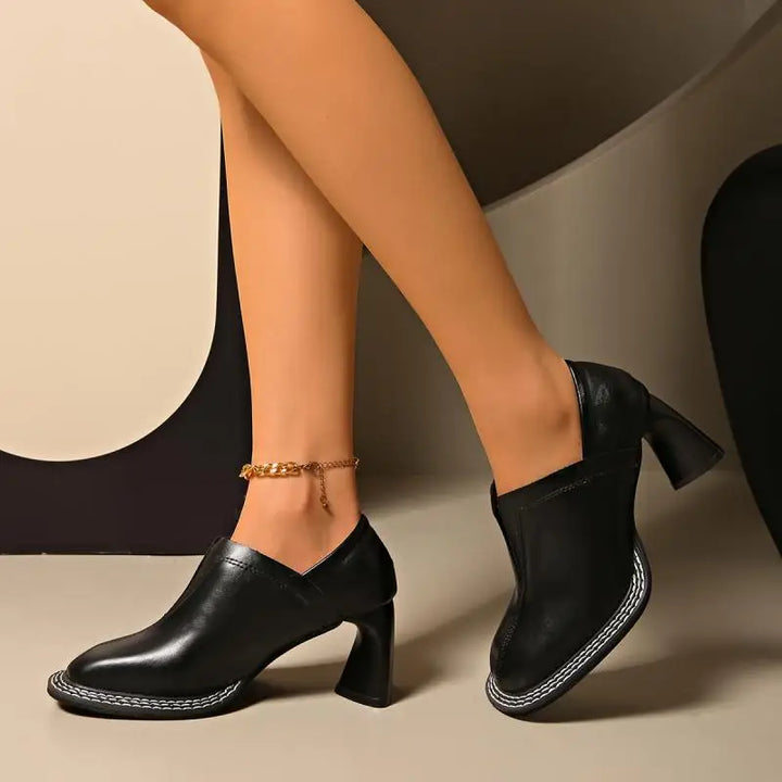 Woman wearing black square toe loafers with block heel