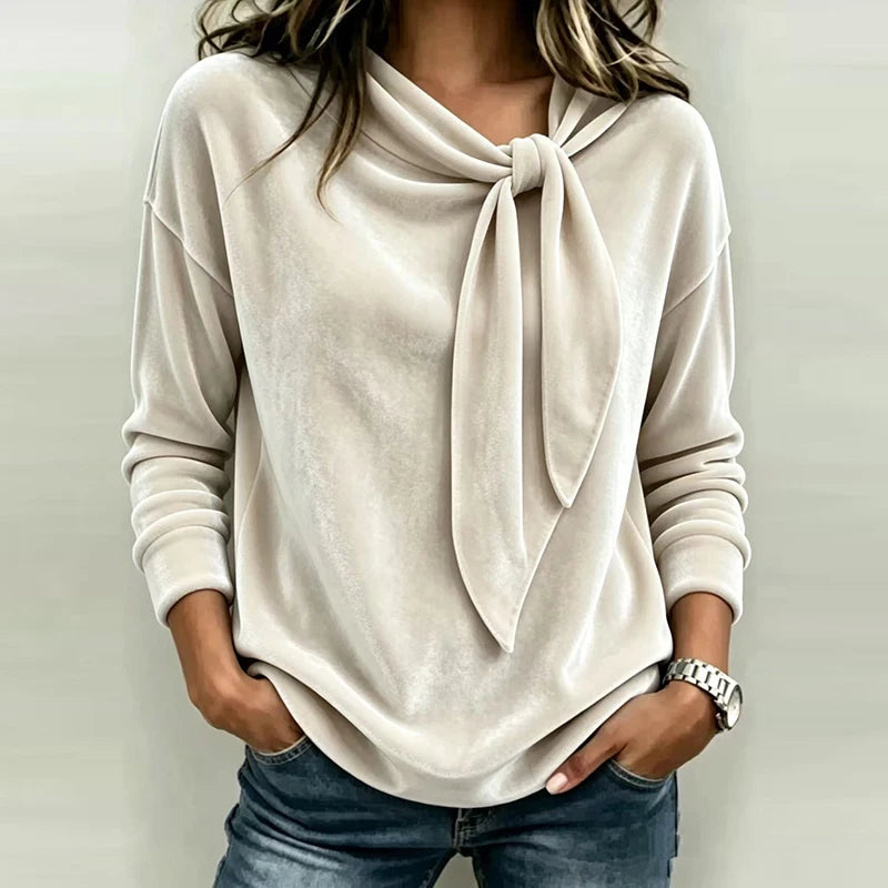 Woman wearing beige velvet bow neck pullover top