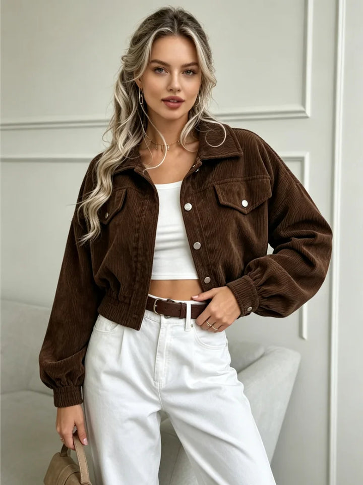 Front view of brown corduroy cropped jacket over white top