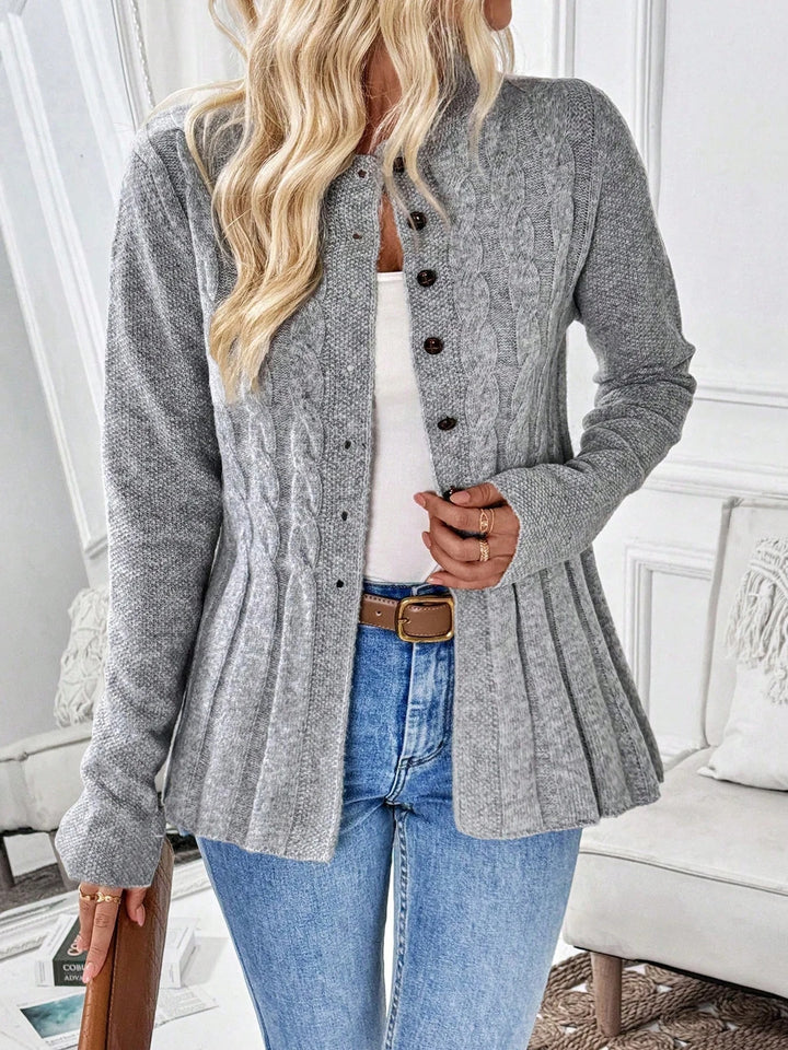 Woman wearing gray cable knit peplum cardigan buttoned partway, front view