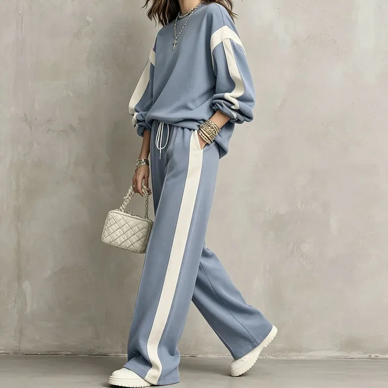 Woman wearing blue color block sweatshirt and wide leg pants set, side view