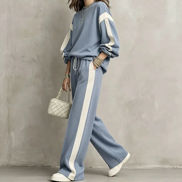 Woman wearing blue color block sweatshirt and wide leg pants set, side view