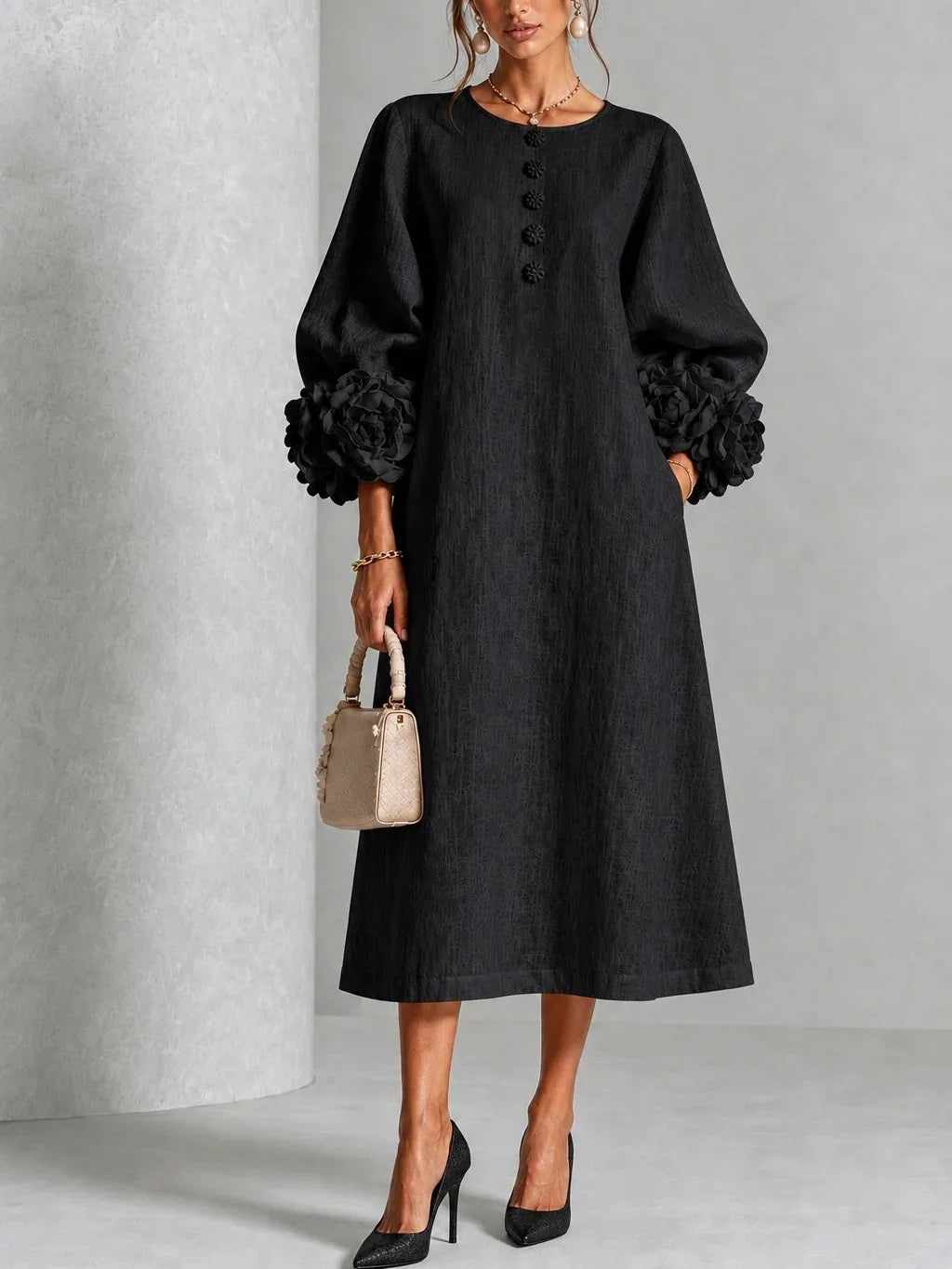 Woman wearing black midi dress with 3D floral lantern sleeve cuffs