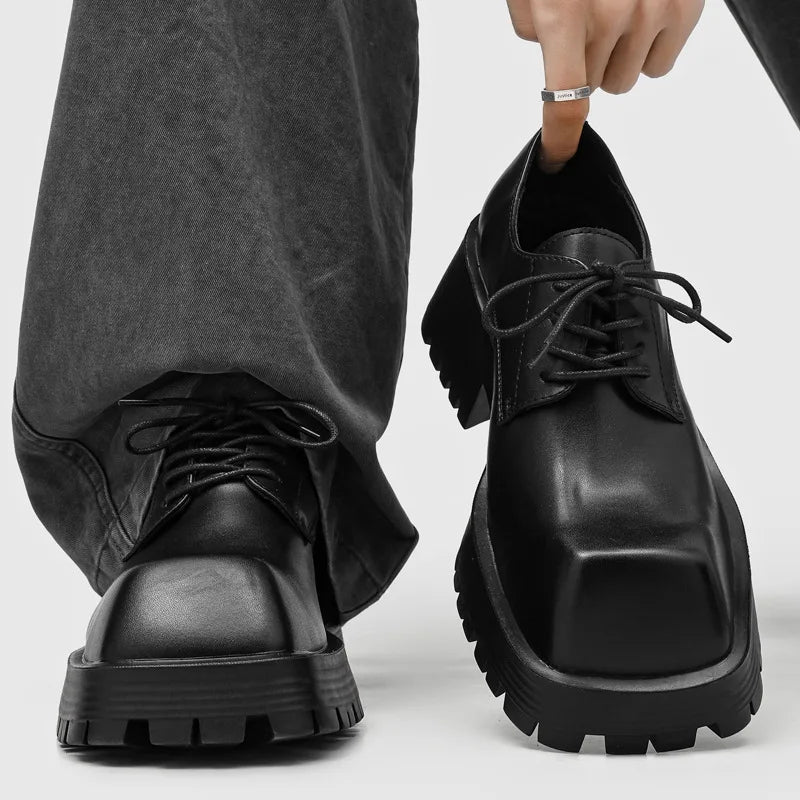 Close up of black platform derby shoes worn with grey jeans