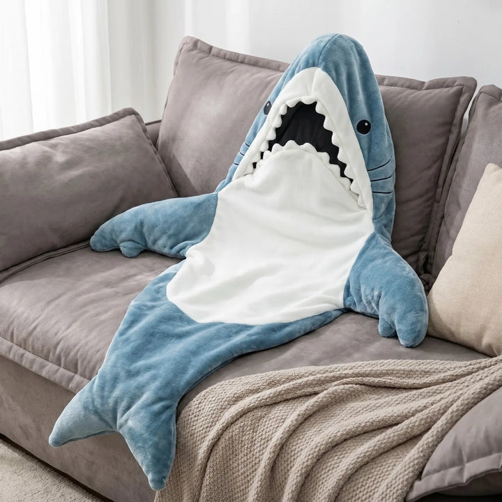 Blue shark wearable blanket draped over sofa cushions
