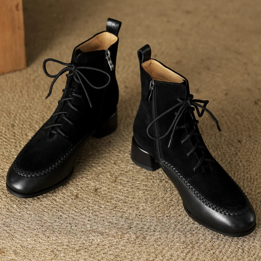 Pair of black suede lace-up ankle boots on rug