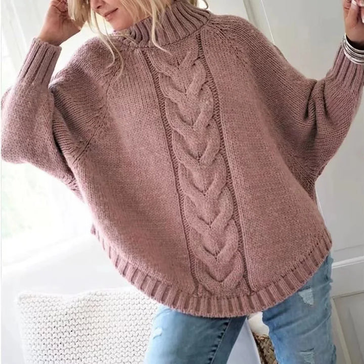 Woman wearing pink cable knit oversized sweater with raised arms