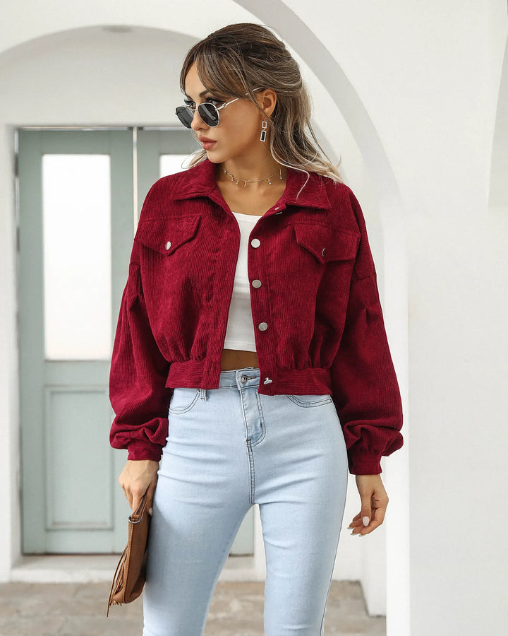 Woman wearing burgundy corduroy cropped jacket with light jeans