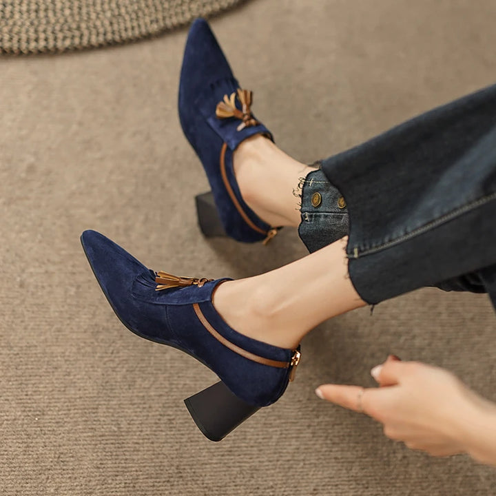 Model wearing navy suede pumps with legs crossed, overhead view