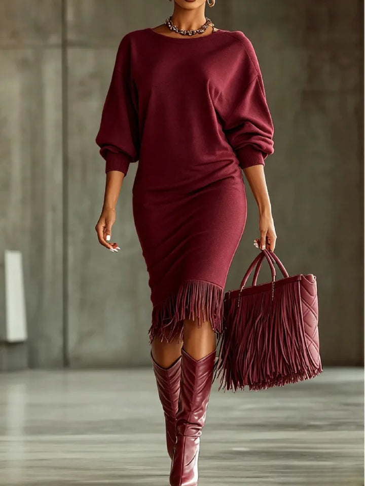Woman wearing wine colored fringe hem sweater dress with fringe tote bag